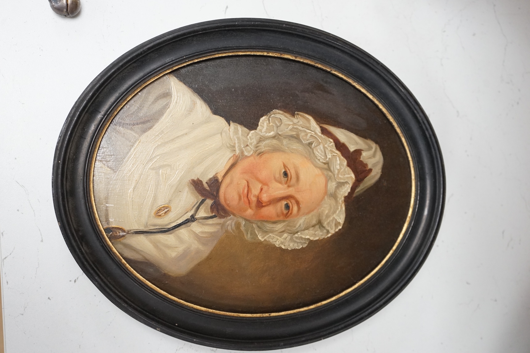 Georgian School, portrait of a lady wearing a bonnet, unsigned, oval oil on panel, 26 x 20cm, housed in an ebonised frame